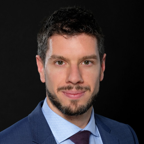 A man in a suit and tie is posing for a photo.