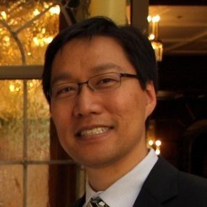 A man in a suit and tie smiles for the camera.